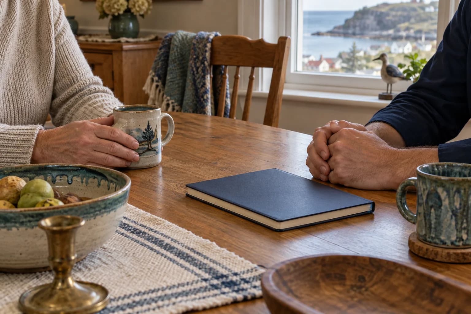 Two adults sitting at a wooden table for a quiet conversation about household belongings