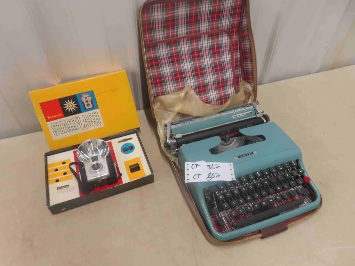 Teal manual typewriter and vintage box camera